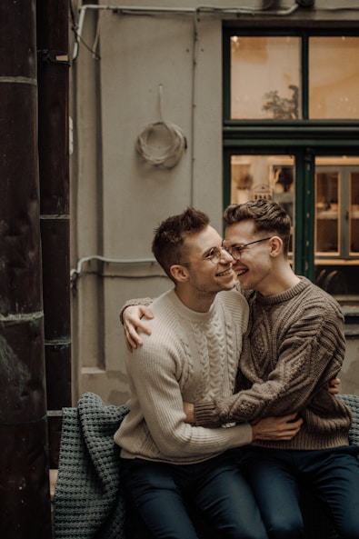 man in gray sweater sitting beside woman in gray sweater