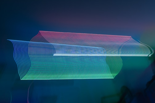 Dynamic close-up of a soundwave visualizer glowing in electric teal against a dark background.
