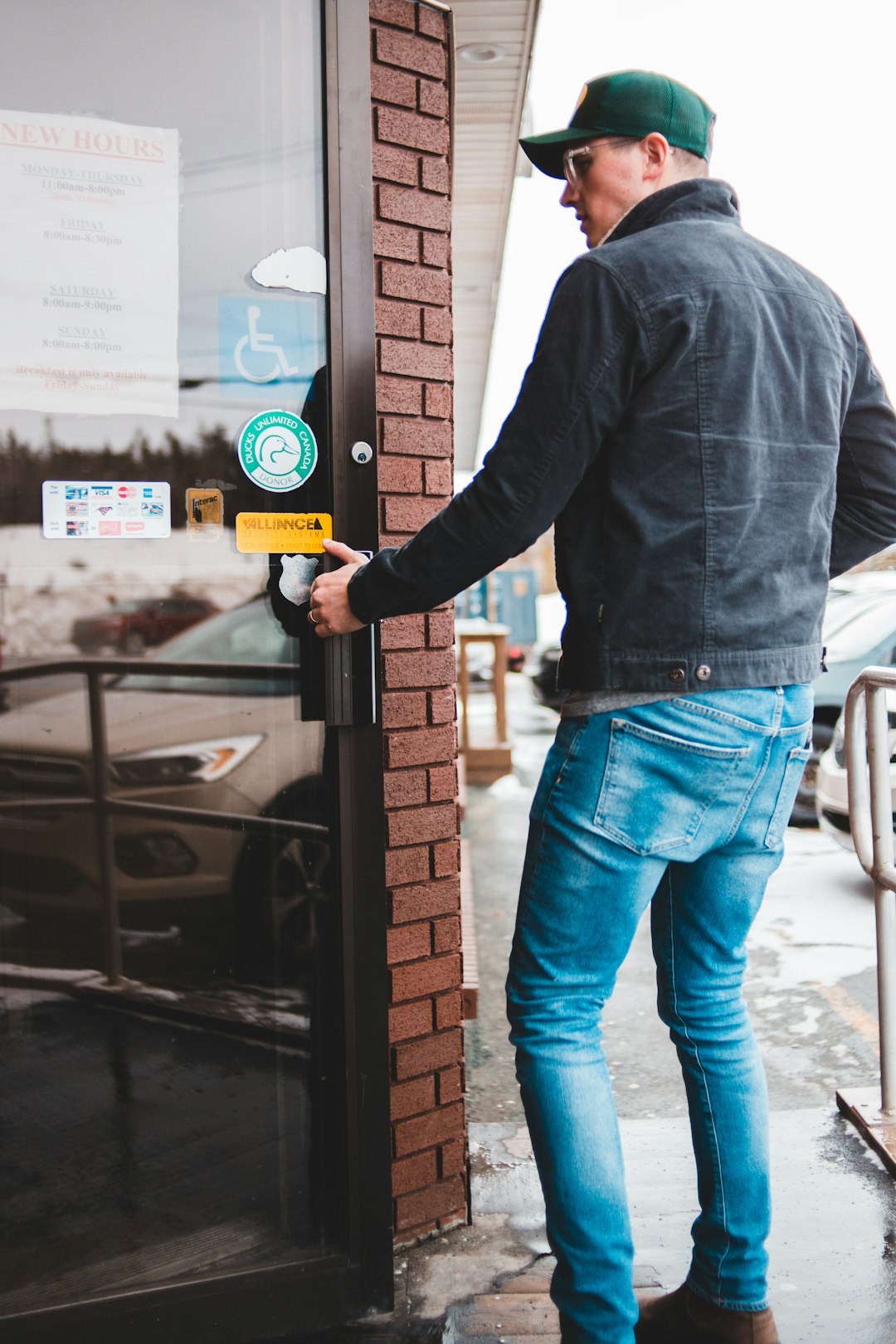 man in black long sleeve shirt and blue denim jeans holding yellow and white labeled box