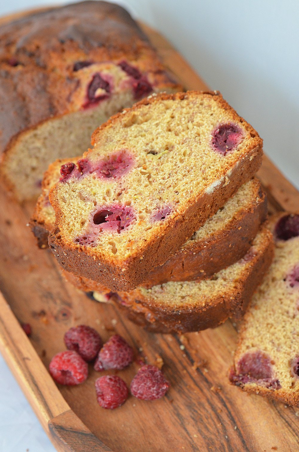 brown bread with red fruit on white ceramic plate