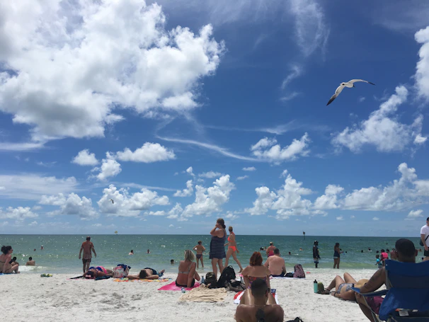 A vibrant beach scene with colorful frisbees scattered on the sand under a bright blue sky.