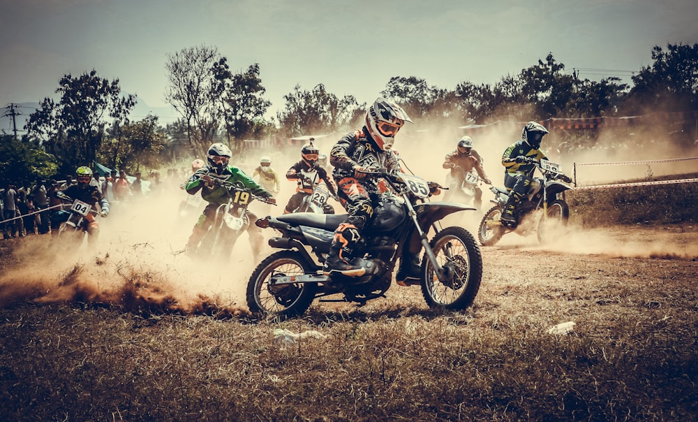 Personas que montan motocicletas en un campo de hierba marrón durante el día