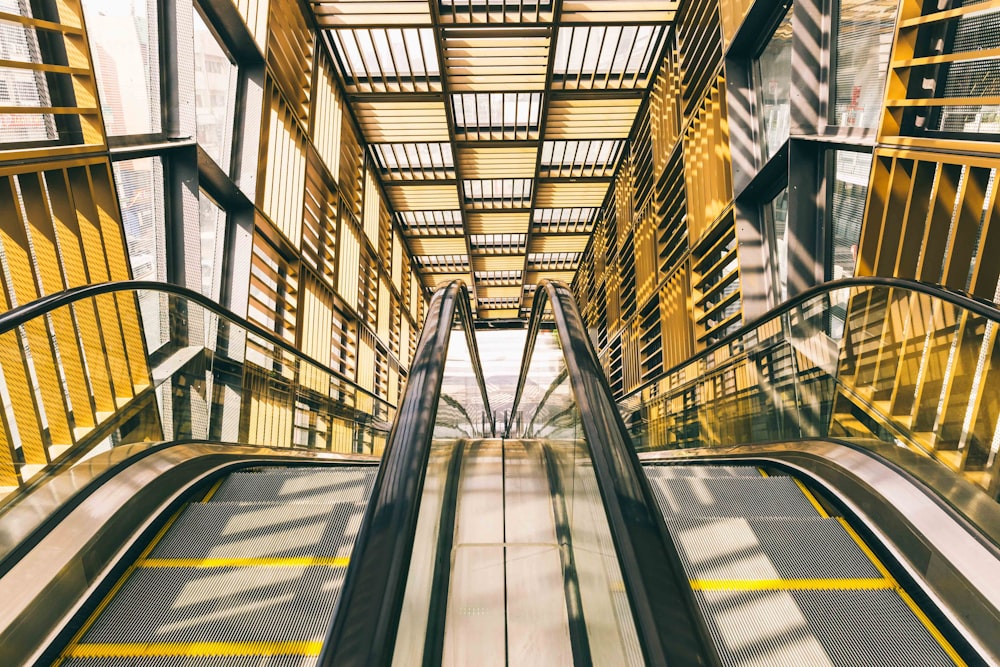 an escalator in a building with yellow railings