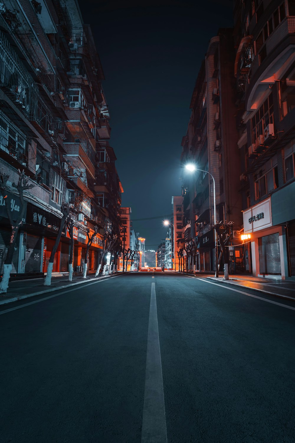 empty road between high rise buildings during night time