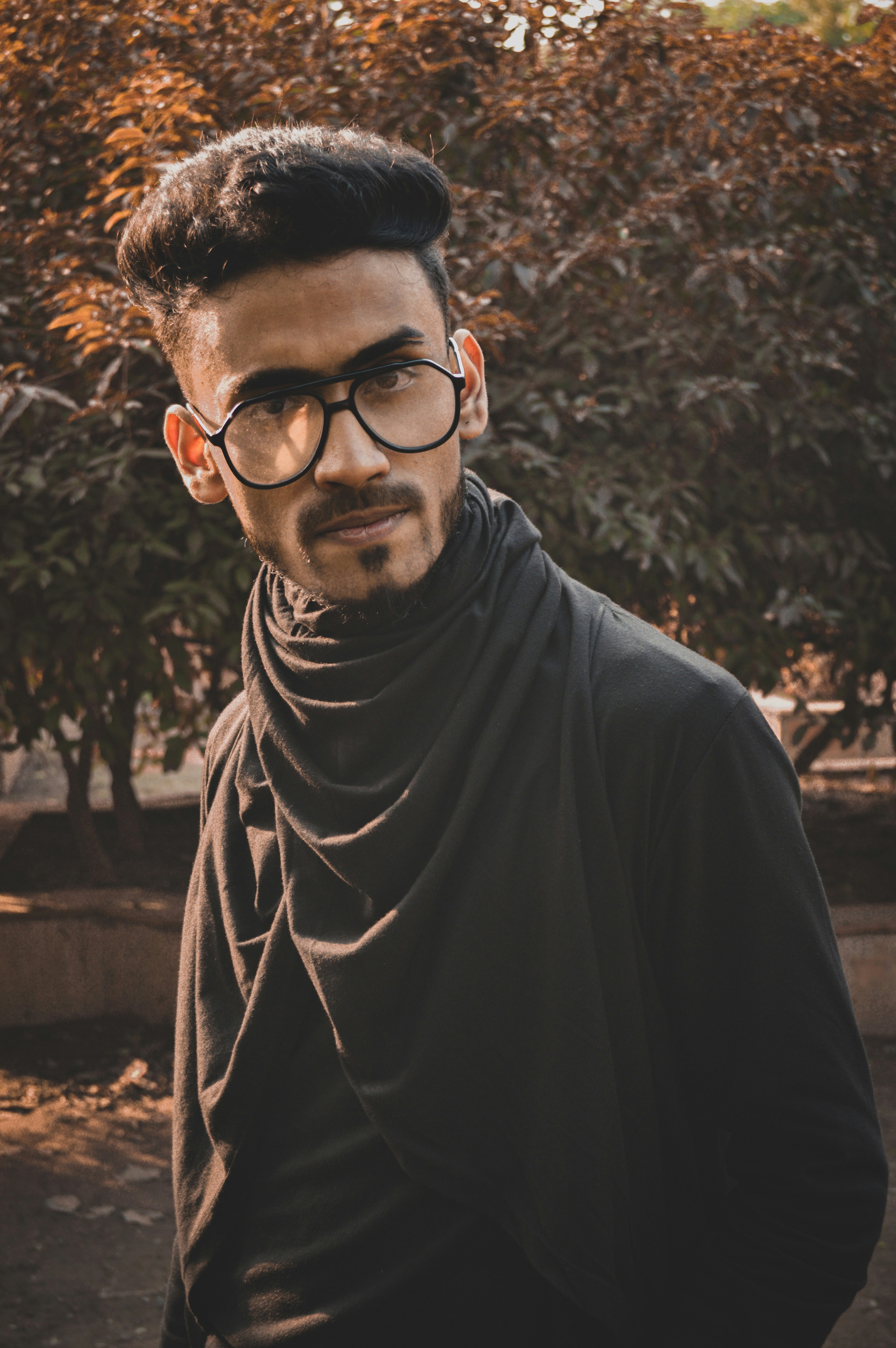 黒いフレームの眼鏡をかけた黒いシャツの男