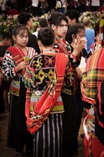 A vibrant gathering of diverse tribal members from Assam sharing traditional attire and smiles.