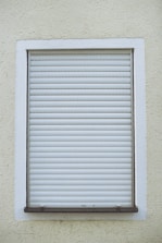 Close-up of a modern motorized roller shutter being installed on a window.