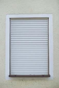 white window blinds on white concrete wall