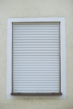 A satisfied customer inspecting their newly fixed rolling shutter outside their house.