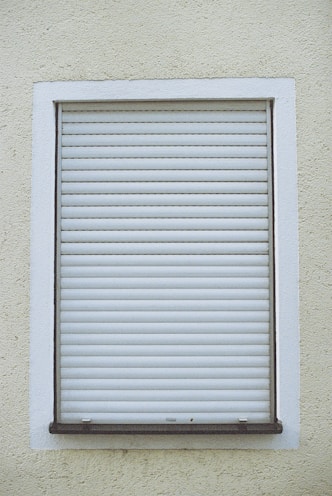white window blinds on white concrete wall