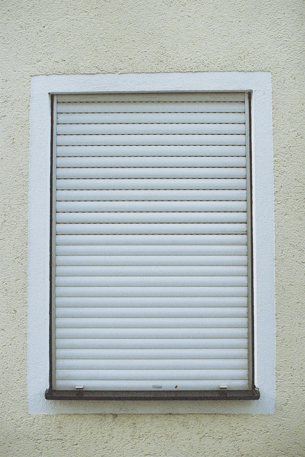 white window blinds on white concrete wall