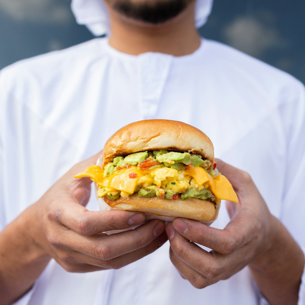 person holding burger with patty and lettuce