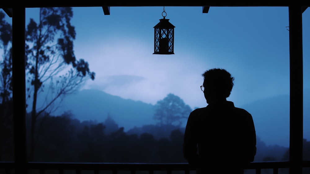 silhouette of man standing near mountain during daytime