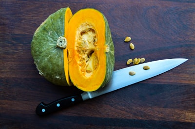 sliced yellow fruit beside knife squash teams background