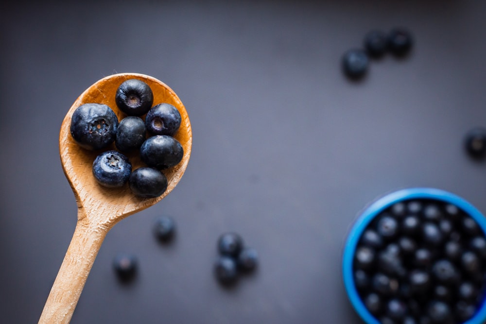 black berries on brown wooden spoon