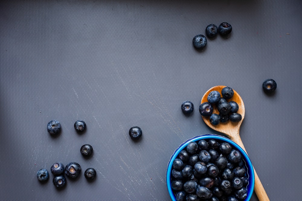 black berries on blue ceramic bowl