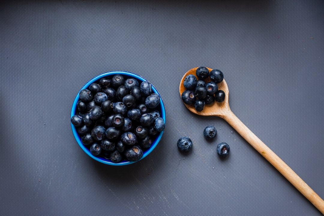 blue berries on brown wooden spoon