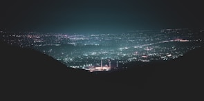 silhouette of person standing on rock formation during night time