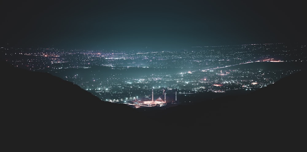 silhouette of person standing on rock formation during night time