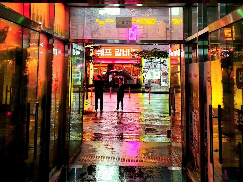 man in black jacket walking on sidewalk during nighttime