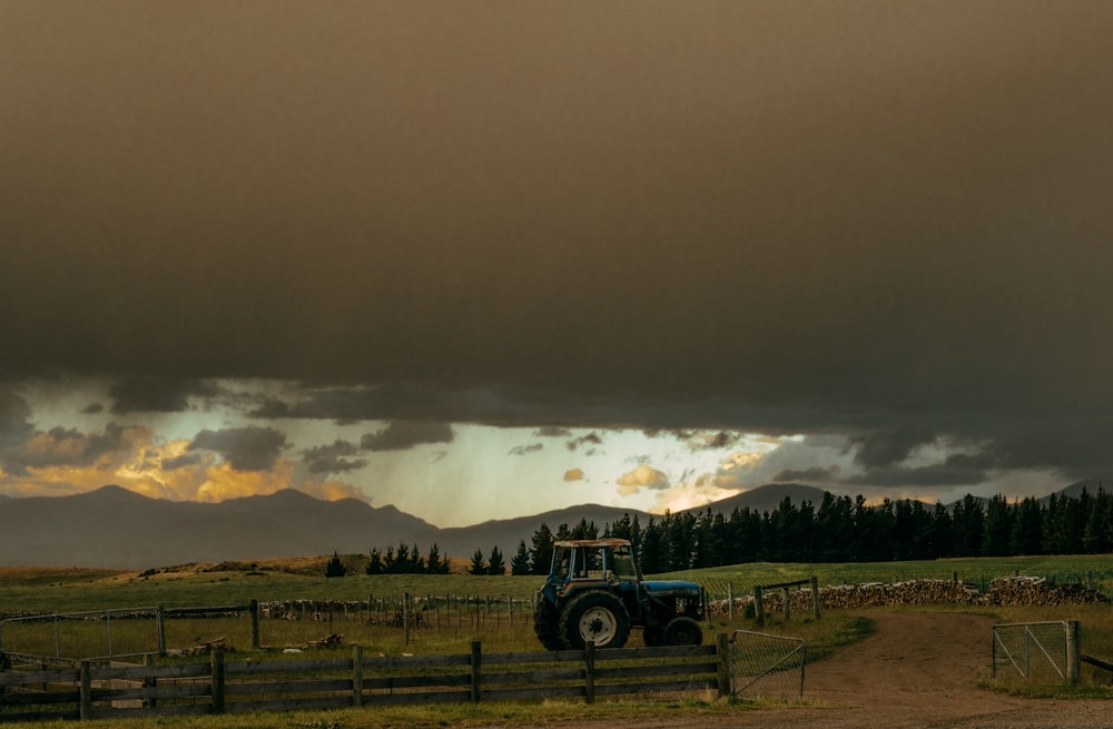 black tractor on green grass field under gray sky