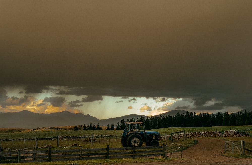 tracteur noir sur un champ d’herbe verte sous un ciel gris