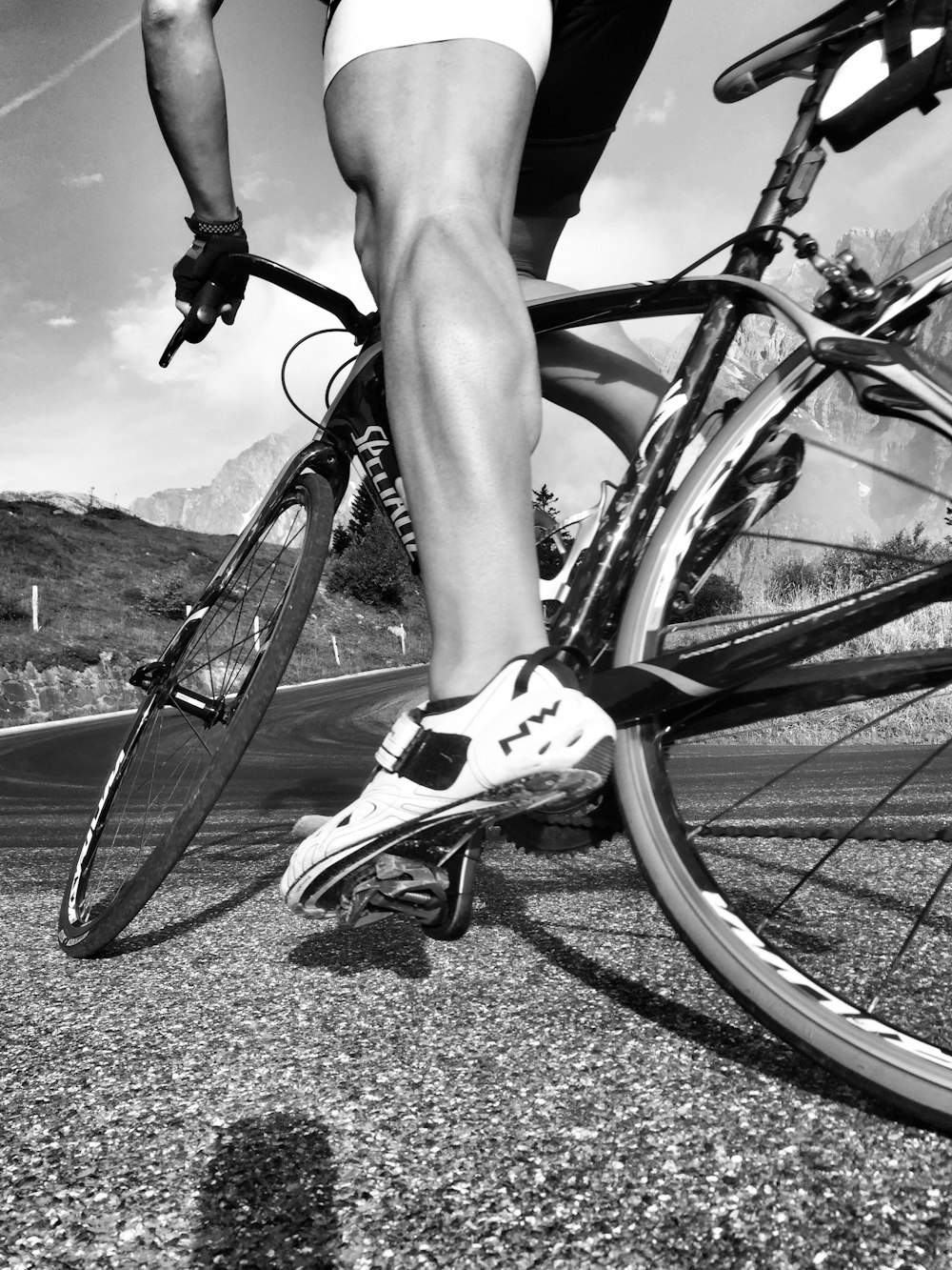 grayscale photo of person riding on bicycle