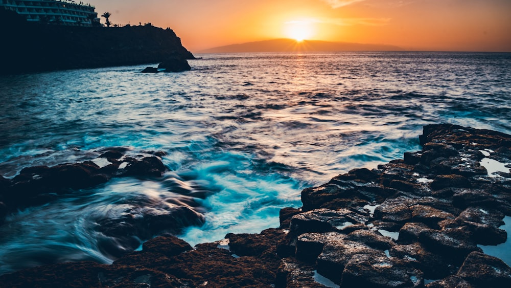 ocean waves crashing on rocks during sunset