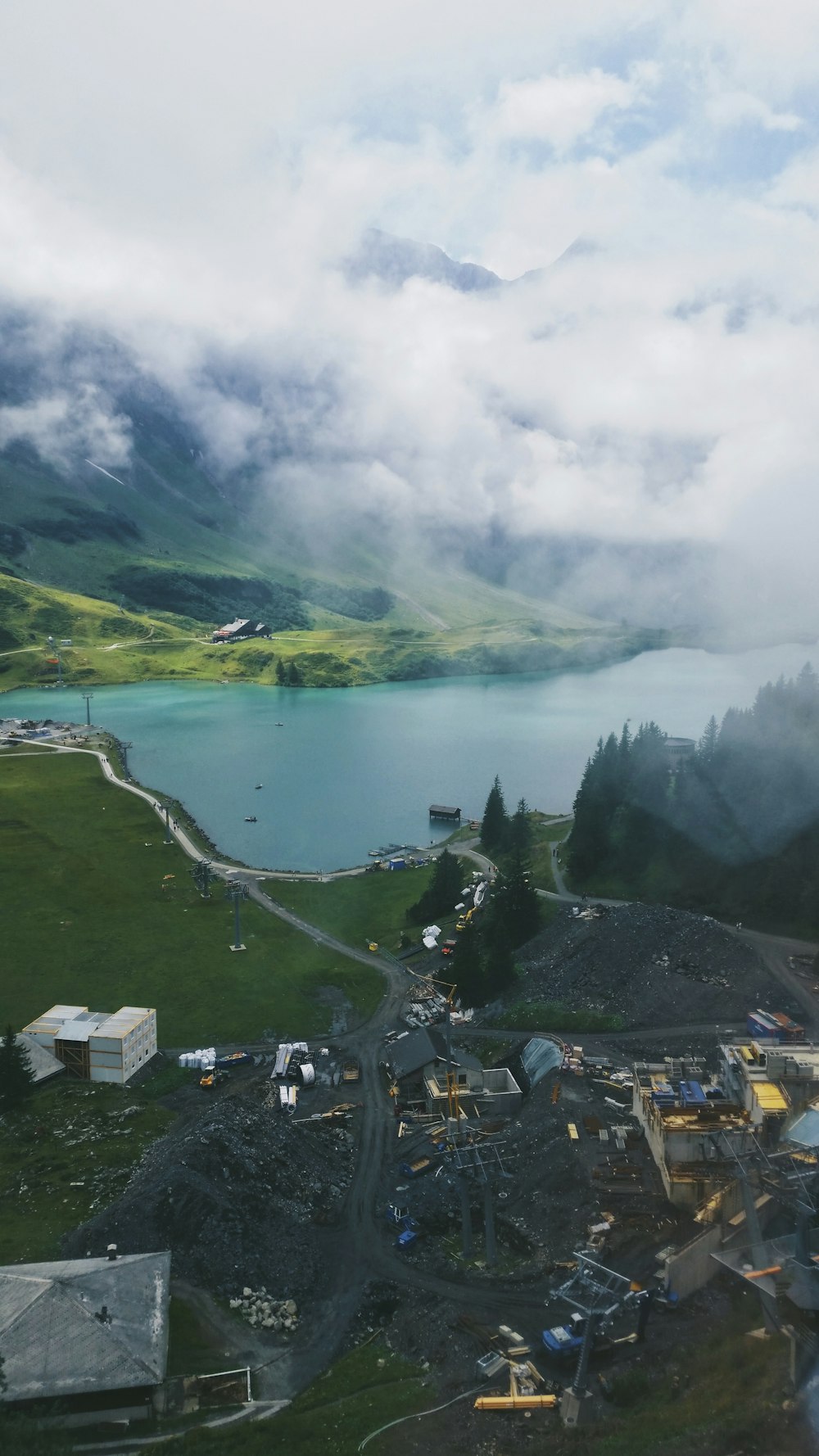 houses near lake under white clouds during daytime