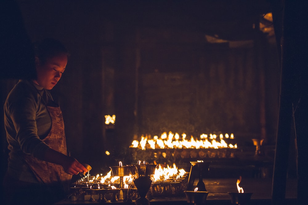 촛불을 든 테이블 근처에 서 있는 회색 양복을 입은 남자