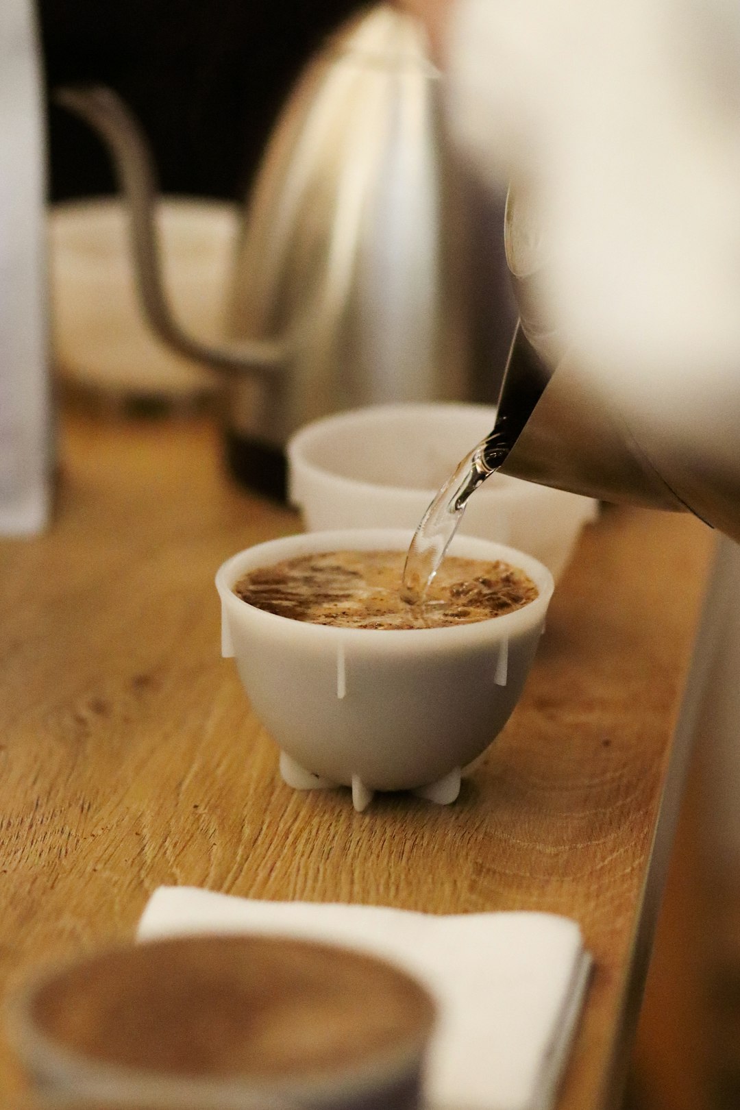 white ceramic cup with silver spoon on brown wooden table