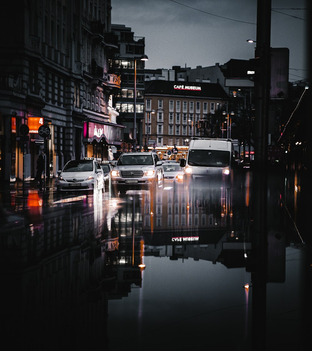 white boat on water in between buildings during night time