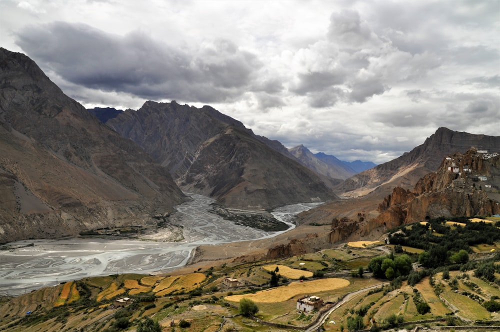 brown and green mountains under white clouds during daytime