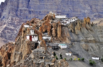 white and blue building on brown rocky mountain during daytime