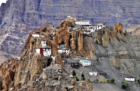 white and blue building on brown rocky mountain during daytime