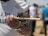 Close-up of a hand holding a wild boar cravstix stick against a rustic wooden table.