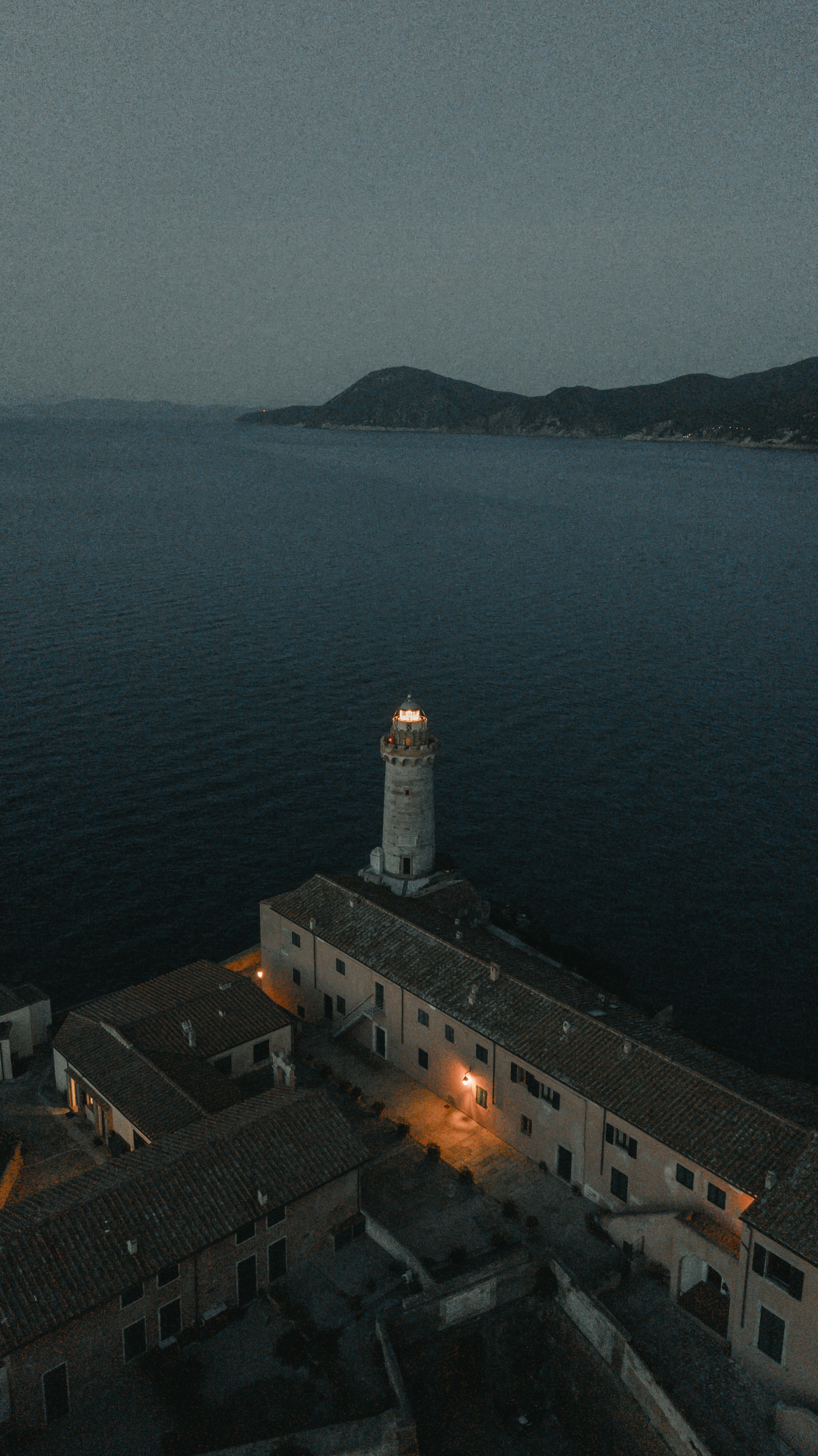 Faro de hormigón blanco cerca de la masa de agua durante el día