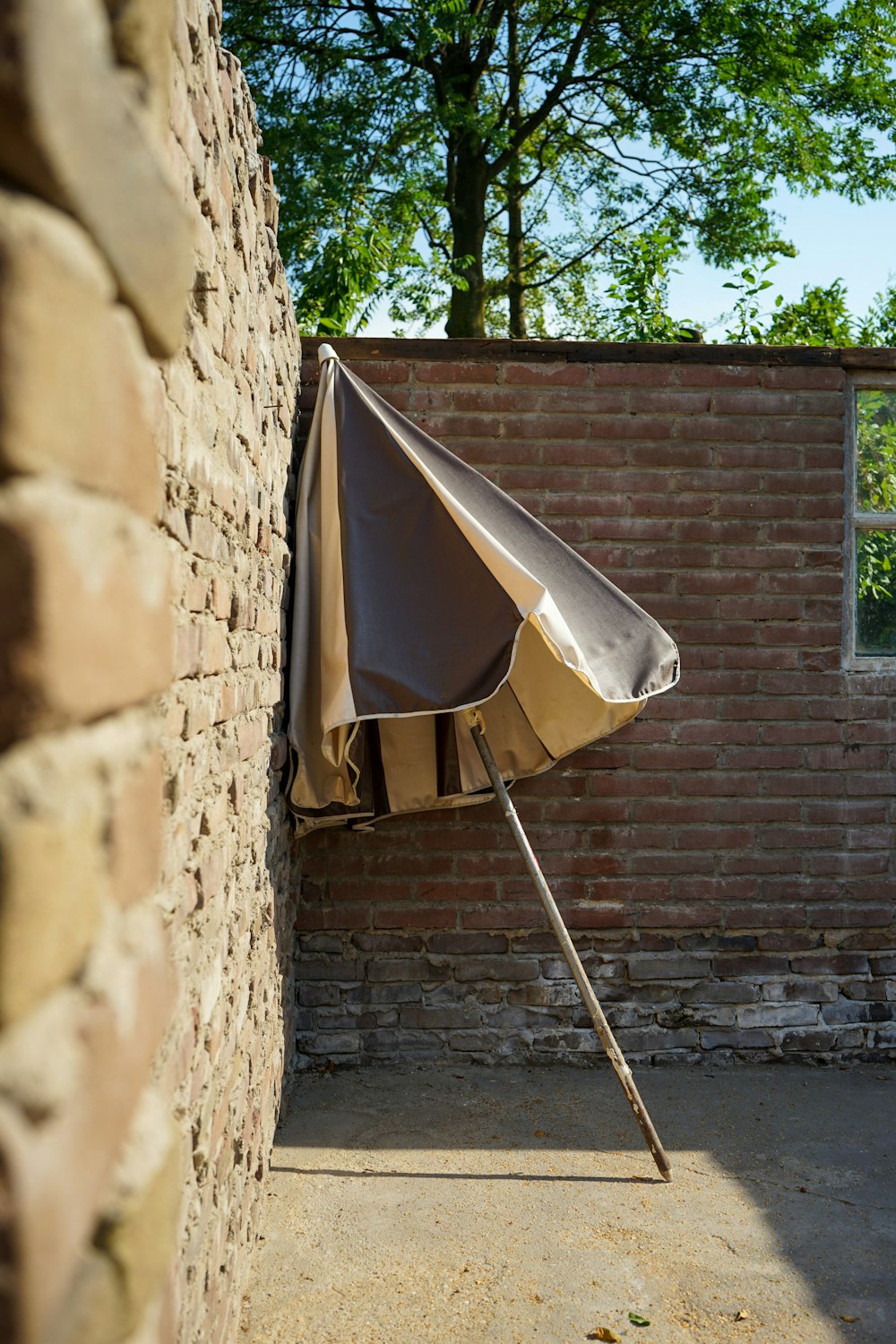 white umbrella on brown brick wall