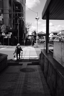 A friendly operator helping an elderly woman cross a street safely in a calm neighborhood.