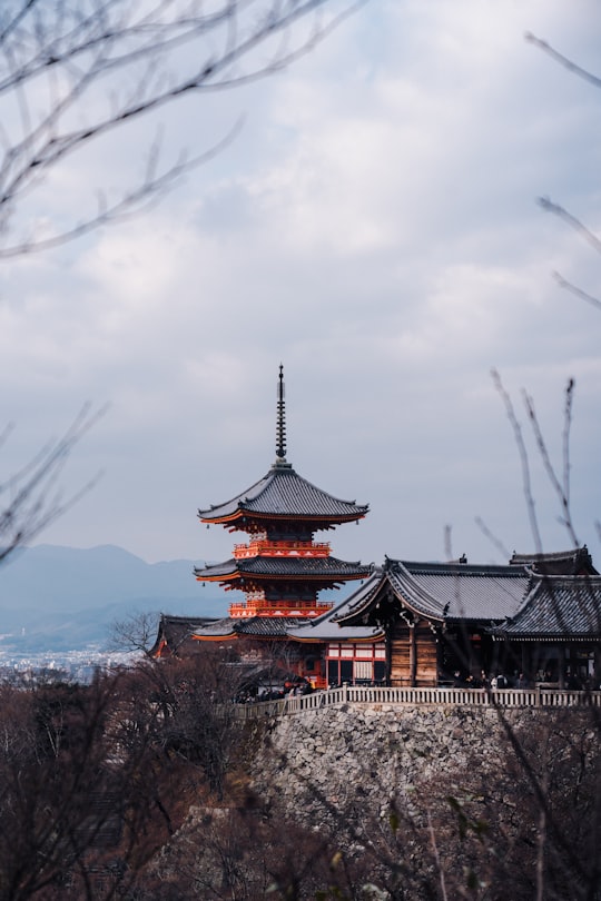 brown and white temple under white clouds during daytime in Kiyomizu-dera Japan