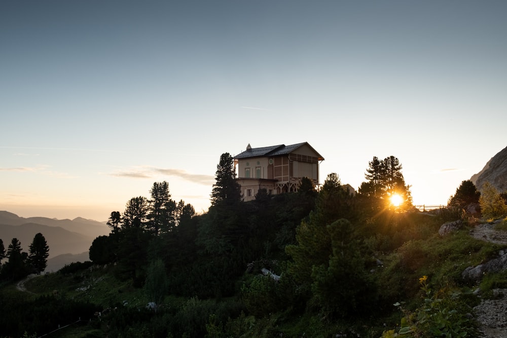 Braunes Betongebäude, umgeben von grünen Bäumen bei Sonnenuntergang