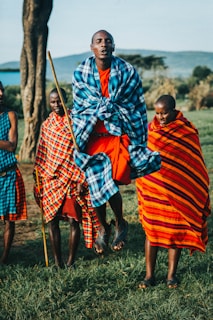 woman in red and blue dress holding brown stick