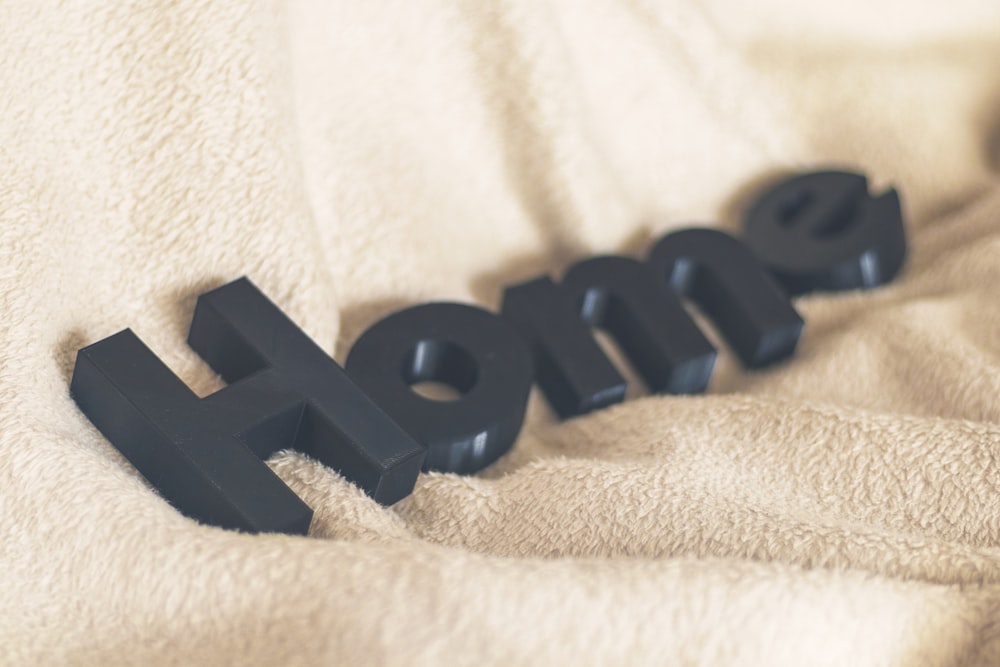 black plastic letter b on white textile