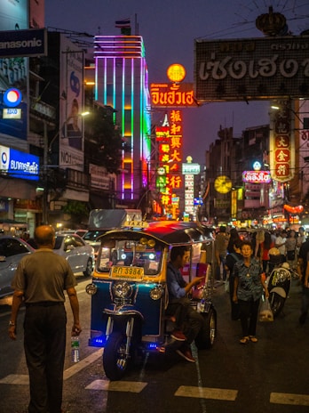 The vibrant streets of Bangkok at night, illuminated with colorful lights and bustling with energy.
