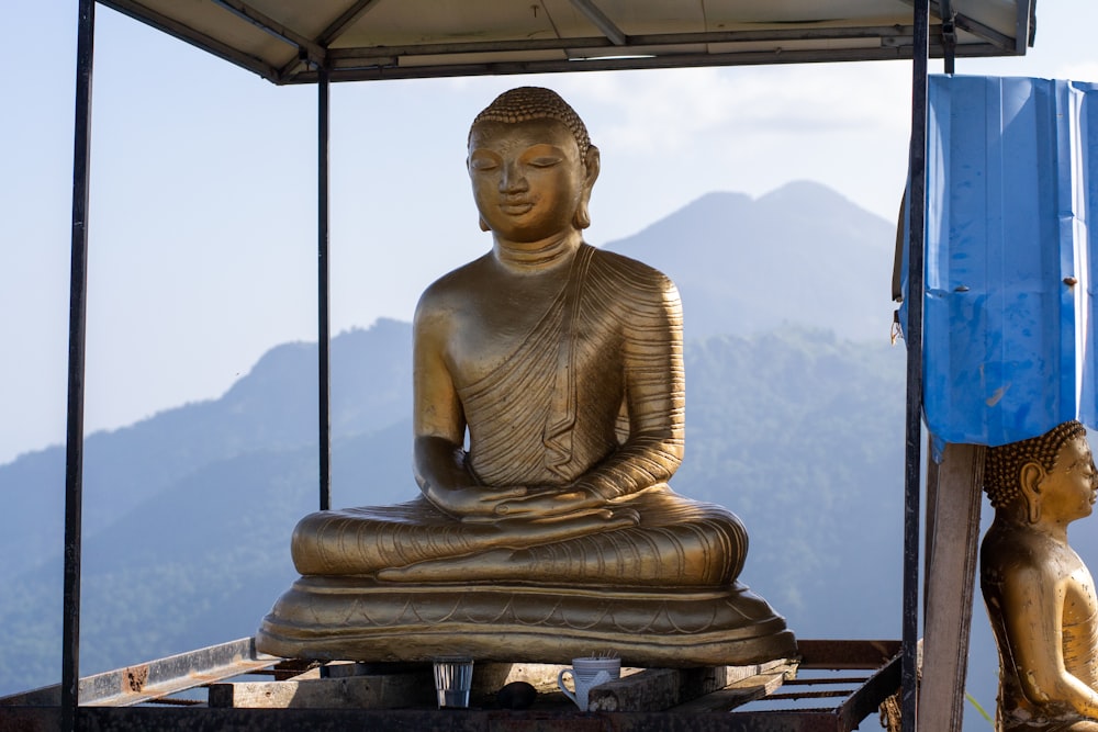 Estatua de Buda de oro sobre mesa de madera marrón