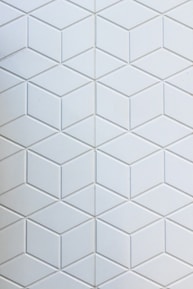 Minimalist pattern of interlocking slate and charcoal hexagons representing encrypted data.