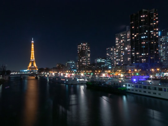 lighted eiffel tower near body of water during night time in Eiffel Tower France
