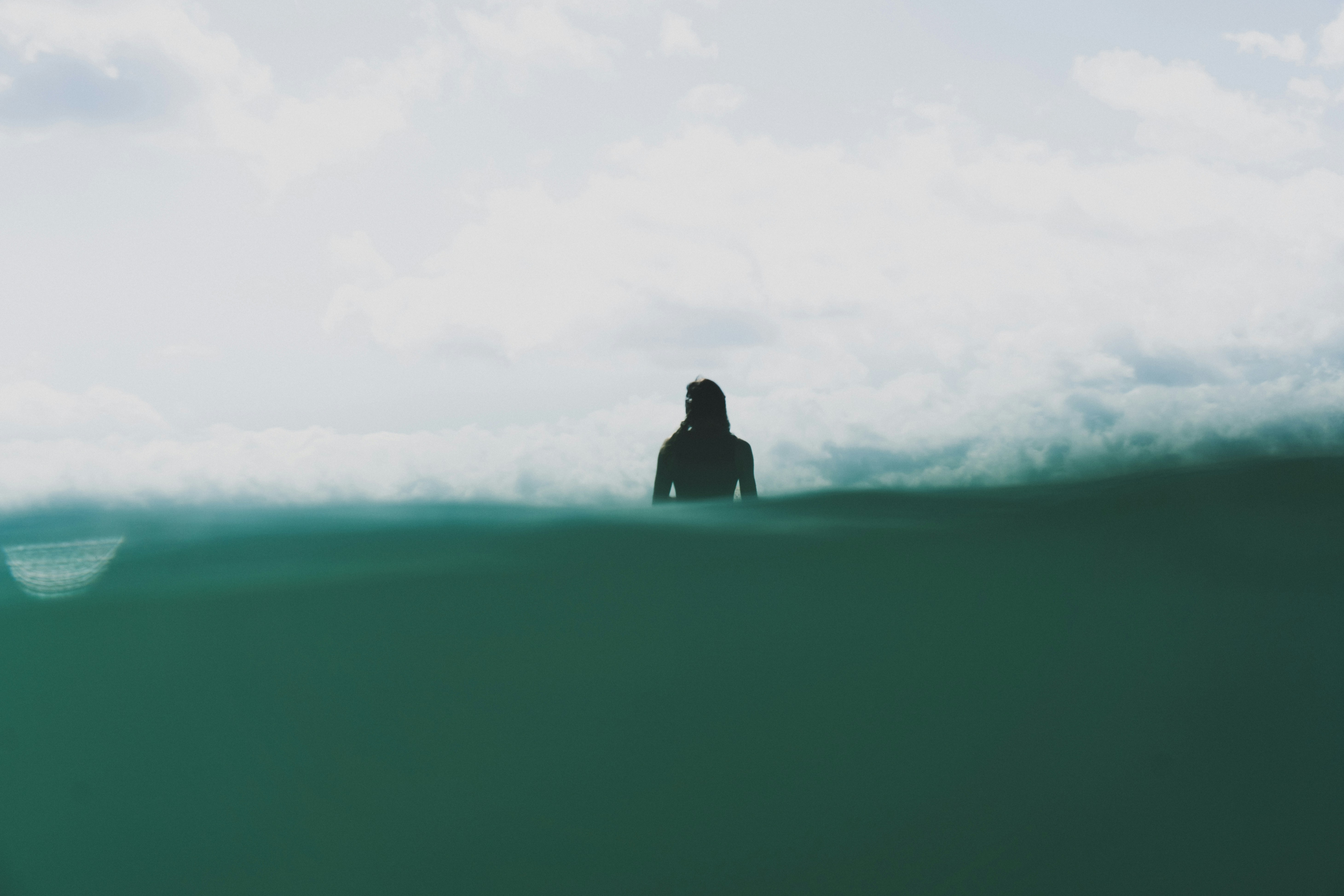 A silhouette of a surfer woman.