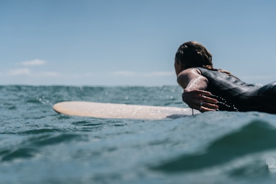 woman in black and white bikini top on body of water during daytime in Mount Maunganui New Zealand