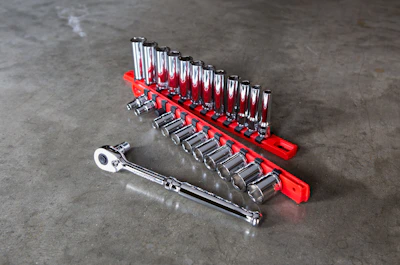 A set of shiny spanners of different sizes laid out on a workbench.